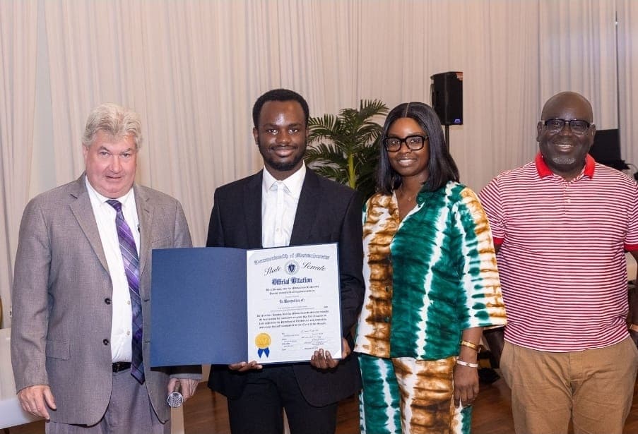 A young leader holds his Official Citation with Senator Michael Brady and guests.