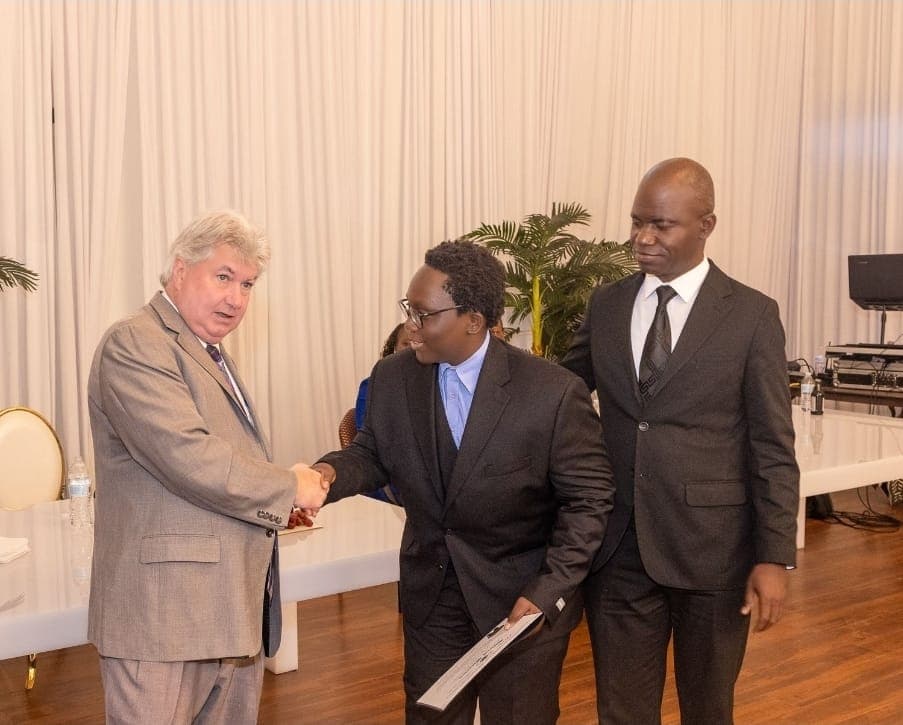 Senator Michael Brady shakes hands with a young leader as Charles Awodu looks on.